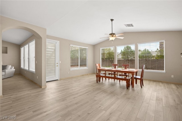 dining space with a healthy amount of sunlight, light wood-style floors, and vaulted ceiling