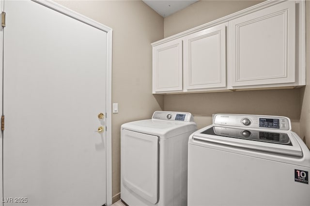 washroom with washing machine and clothes dryer and cabinet space