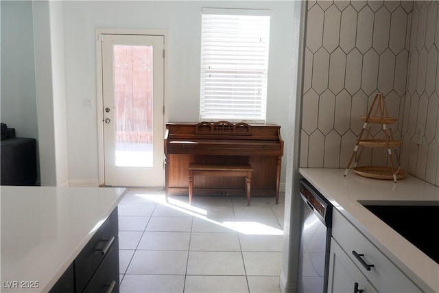 kitchen featuring dishwasher, light countertops, light tile patterned floors, and white cabinetry