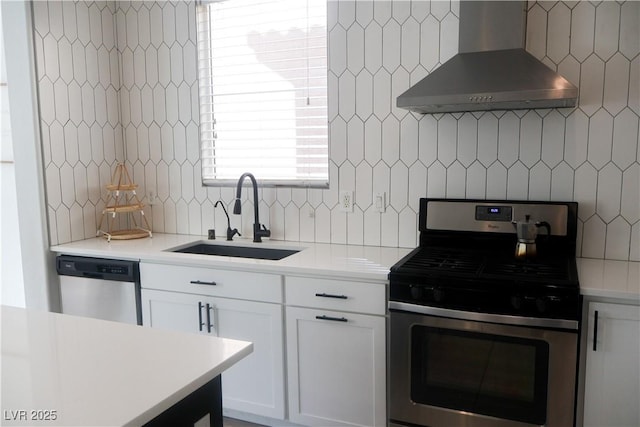 kitchen with a sink, light countertops, wall chimney exhaust hood, and stainless steel appliances