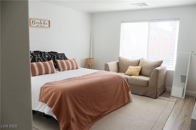 bedroom featuring visible vents, baseboards, and light wood-style flooring