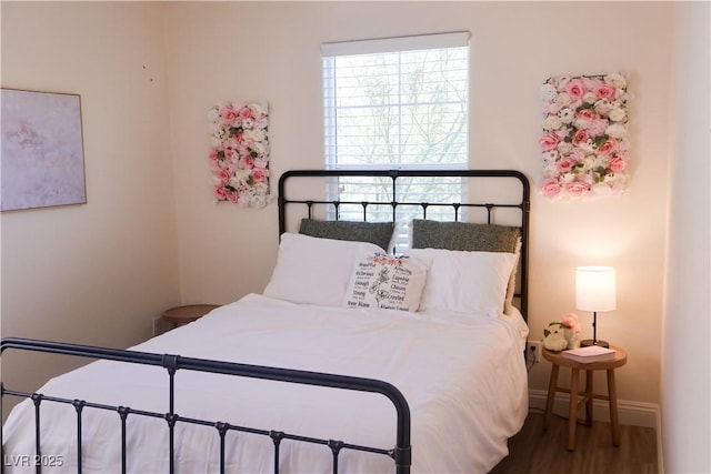 bedroom with baseboards and wood finished floors