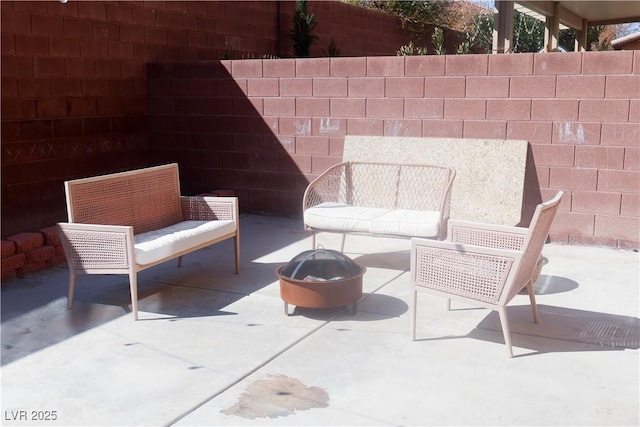 view of patio featuring a fire pit and fence