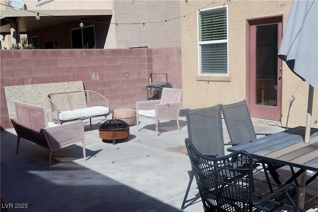 view of patio featuring a fire pit and fence