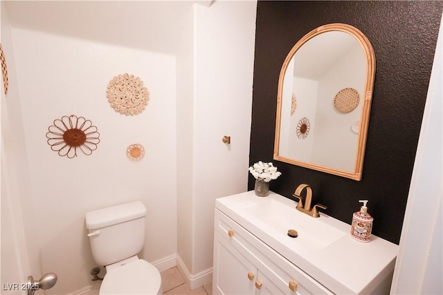 bathroom featuring baseboards, toilet, and vanity