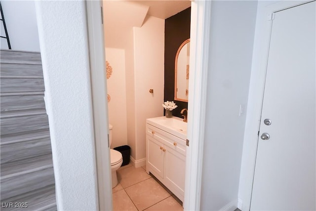 bathroom featuring toilet, tile patterned flooring, and vanity