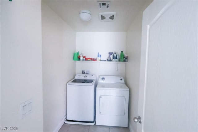 clothes washing area with light tile patterned flooring, separate washer and dryer, visible vents, and laundry area