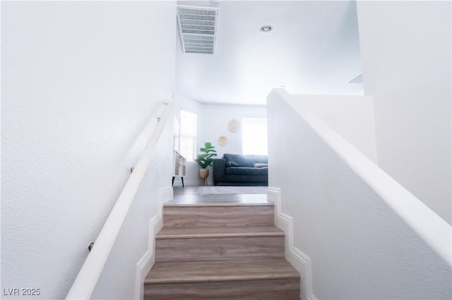 stairs with visible vents and wood finished floors