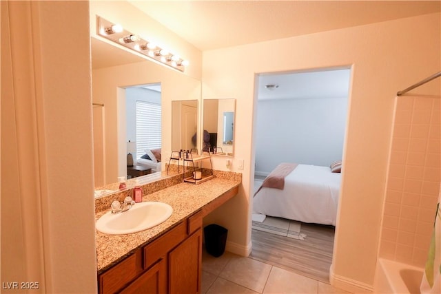 ensuite bathroom with ensuite bathroom, shower / tub combo, tile patterned flooring, and vanity