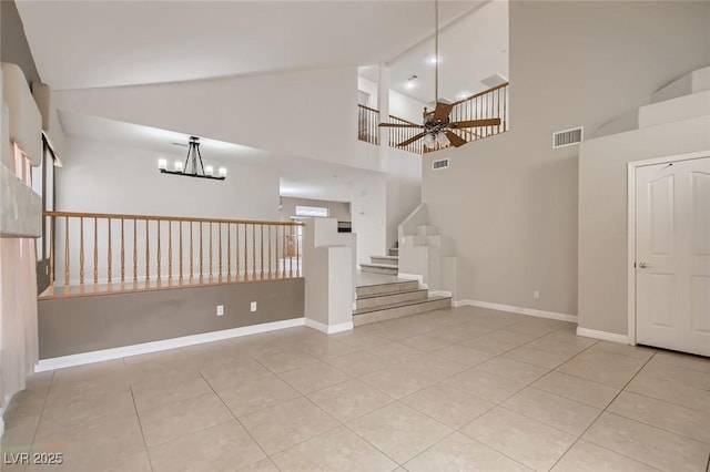 empty room with tile patterned floors, visible vents, stairway, and ceiling fan with notable chandelier