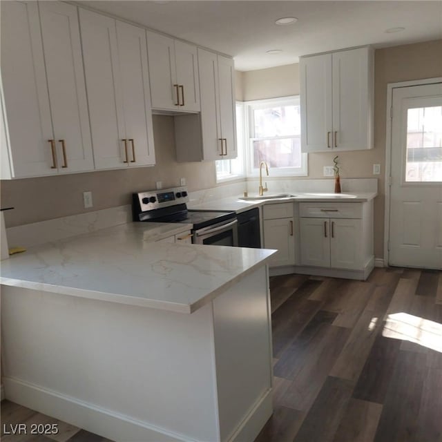 kitchen with a peninsula, electric stove, a healthy amount of sunlight, and a sink