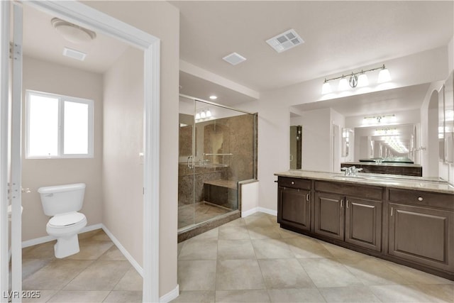 bathroom with toilet, vanity, visible vents, baseboards, and a stall shower