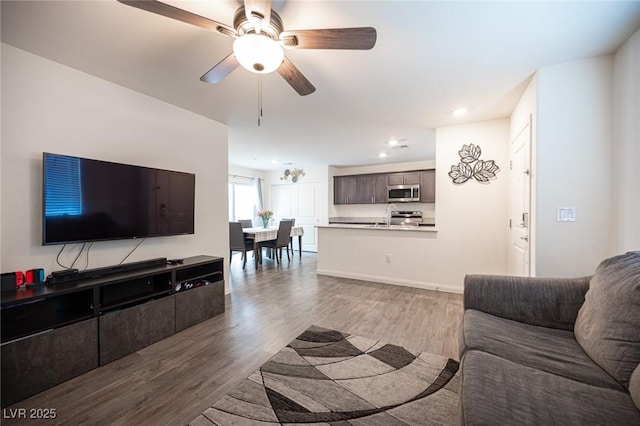 living room with ceiling fan, recessed lighting, baseboards, and light wood-style floors