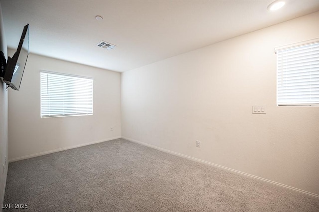 carpeted spare room with baseboards and visible vents