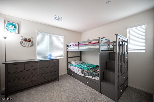 carpeted bedroom featuring visible vents and baseboards