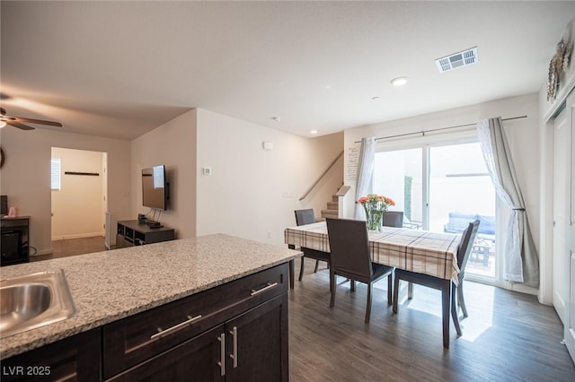 interior space featuring visible vents, dark wood finished floors, ceiling fan, open floor plan, and a sink