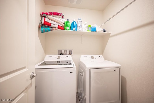 washroom with laundry area, visible vents, and separate washer and dryer