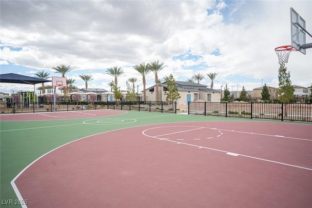 view of basketball court featuring a residential view, community basketball court, and fence