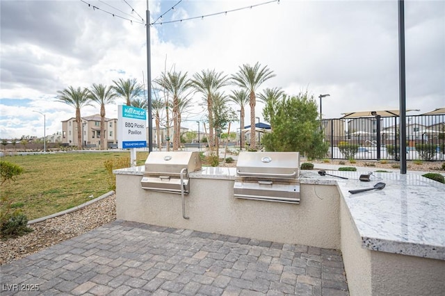 view of community with a yard, a patio, area for grilling, and fence