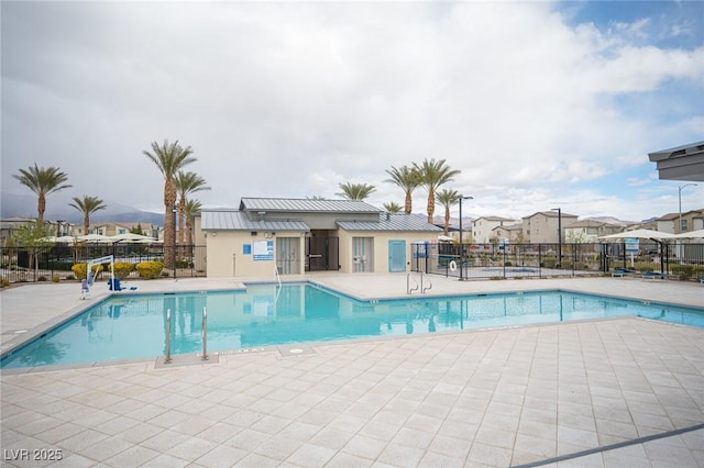 community pool with fence and a patio