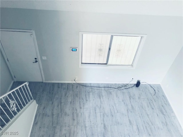 empty room featuring stairs and wood finished floors