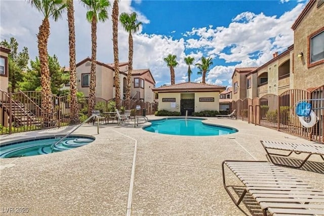 community pool with a residential view, a patio area, and fence