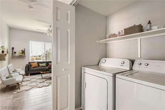 laundry room with ceiling fan, laundry area, light wood-type flooring, and washing machine and clothes dryer