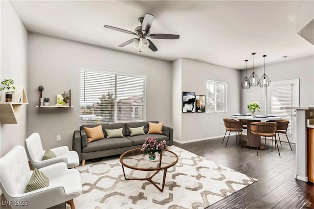 living room with a ceiling fan, dark wood-style flooring, and baseboards