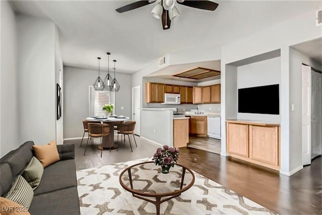 living room featuring dark wood-type flooring, visible vents, and baseboards