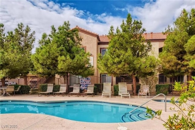 community pool featuring a patio area and fence