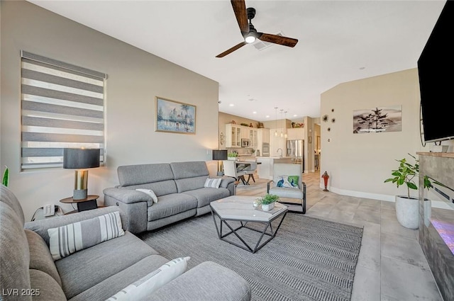 living area with a ceiling fan, recessed lighting, and baseboards