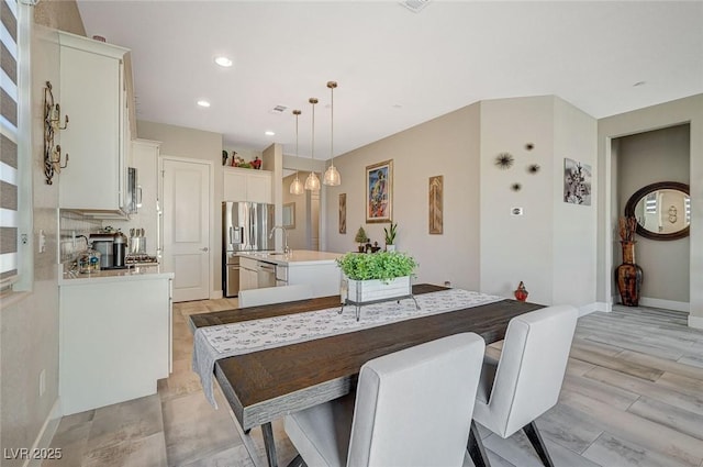 dining room featuring light wood-type flooring, recessed lighting, visible vents, and baseboards