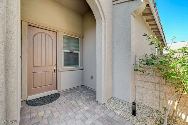 view of exterior entry with stucco siding