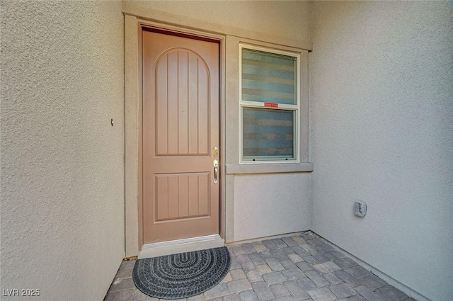 entrance to property featuring stucco siding