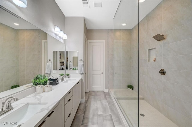 full bathroom with visible vents, walk in shower, and a sink