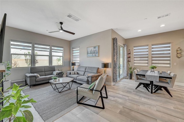 living room with baseboards, recessed lighting, visible vents, and a ceiling fan