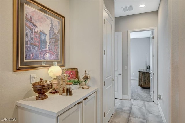 hallway with visible vents and baseboards