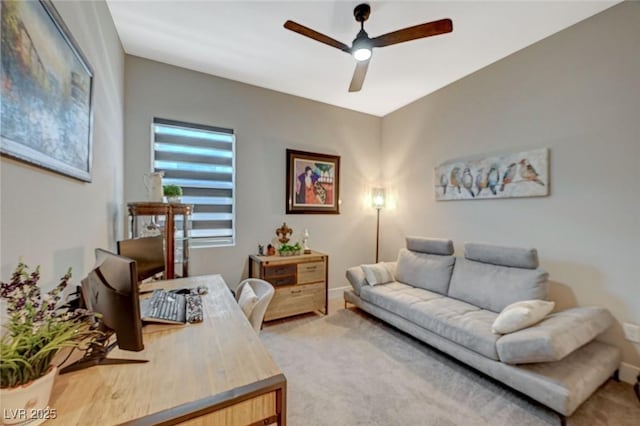 living area featuring baseboards and a ceiling fan