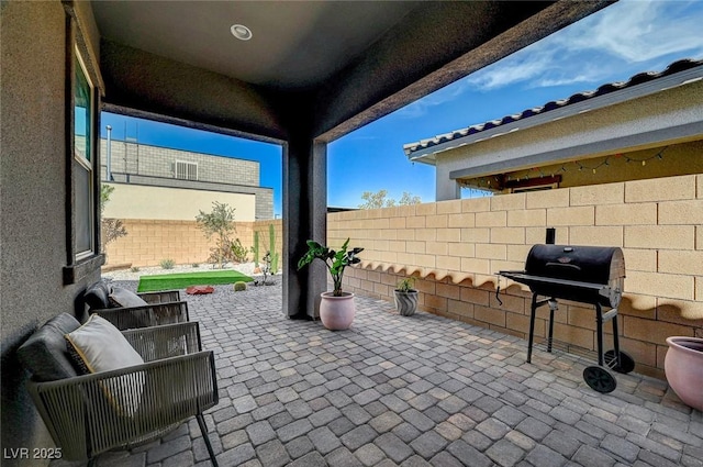 view of patio / terrace with a fenced backyard and a grill