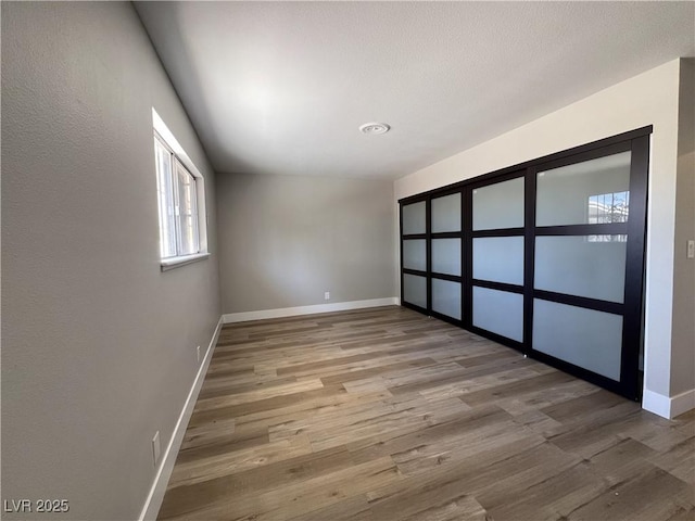 empty room with baseboards and wood finished floors