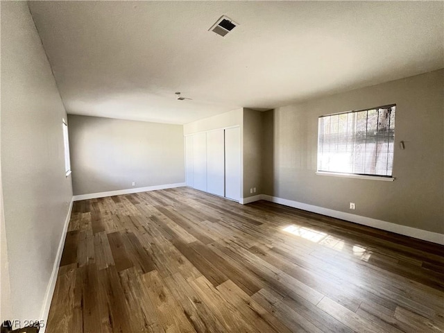 interior space featuring visible vents, baseboards, and wood finished floors