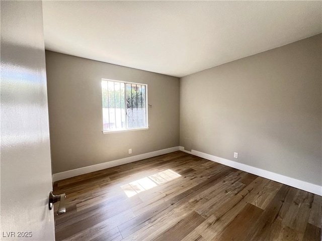 unfurnished room with wood finished floors and baseboards