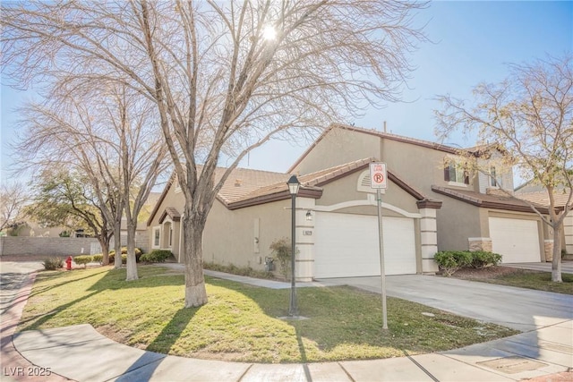 view of front of property with driveway, stucco siding, a tile roof, an attached garage, and a front yard