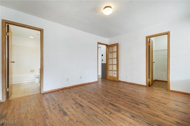 empty room with baseboards and wood finished floors