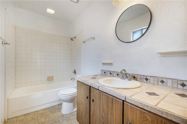 bathroom featuring toilet, shower / washtub combination, and vanity