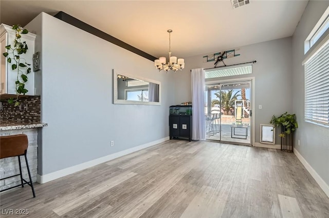 unfurnished dining area with light wood-style floors, a healthy amount of sunlight, and baseboards