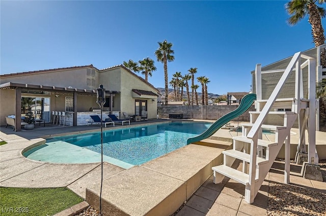 view of pool with a fenced backyard, a fenced in pool, a water slide, and a patio