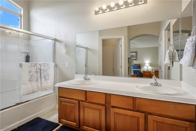 bathroom featuring double vanity, combined bath / shower with glass door, a sink, and connected bathroom