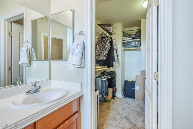 bathroom featuring a spacious closet and vanity