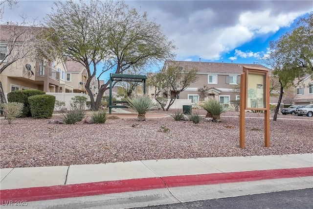 view of front facade with fence and stucco siding